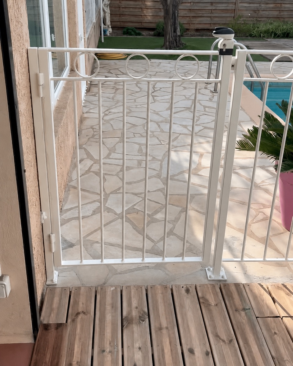 Barrière et portillon de piscine thermolaqués blanc, posés chez un client — résistance aux embruns en bord de mer