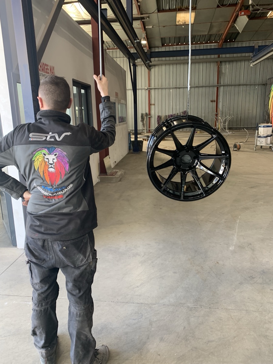 Jante automobile thermolaquée noir brillant suspendue sur la chaîne — STV 83 La Seyne-sur-Mer